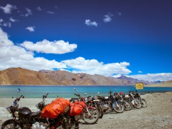 assorted-color motorcycle lot parked beside body of water